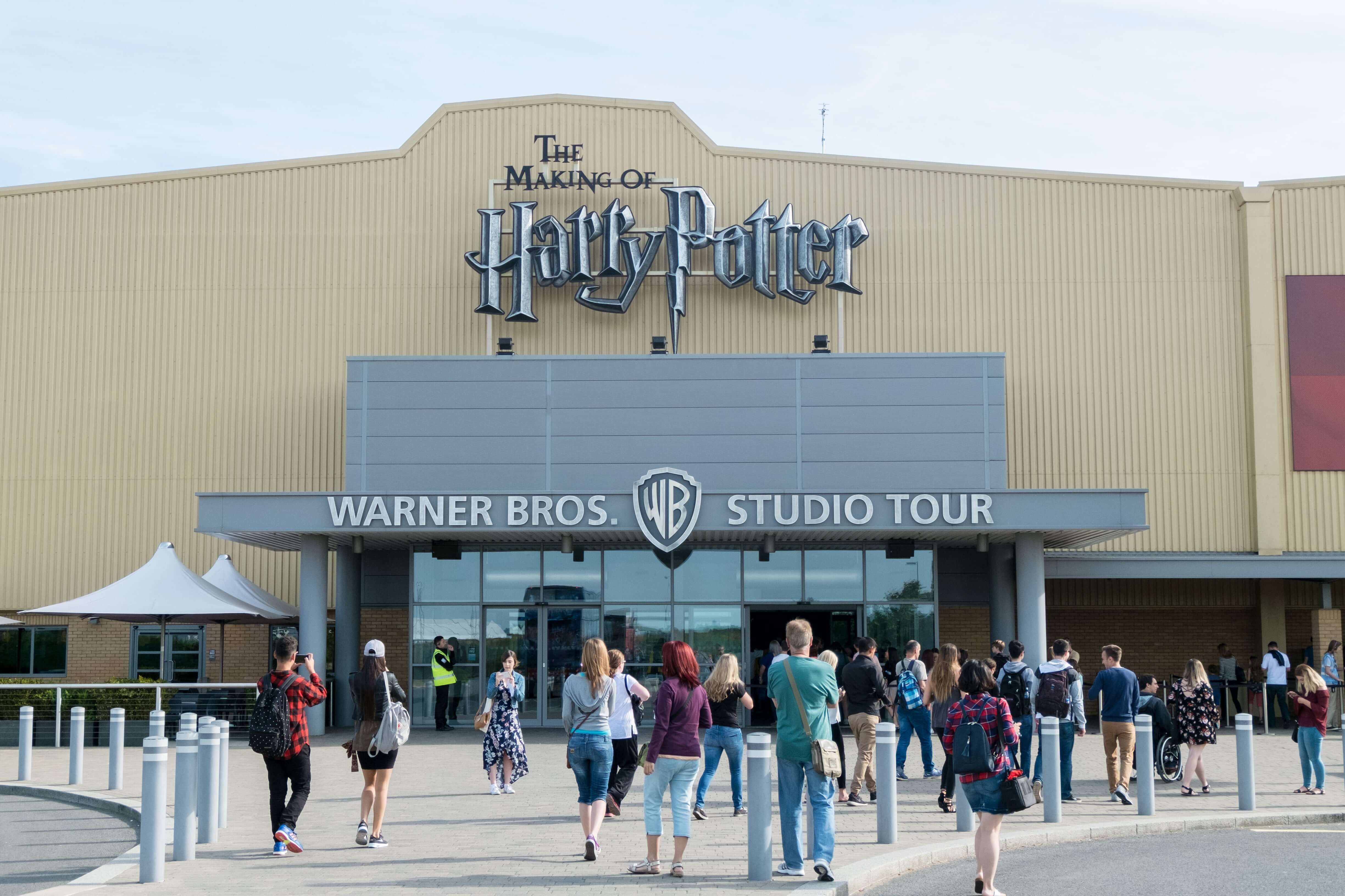 Tourists taking picture in front of the Warner Brothers Studio tour, The making of Harry Potter at Leavesden Studio in London.